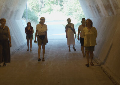 The 6 women walk through a hexagonal tunnel and enjoy the acoustics